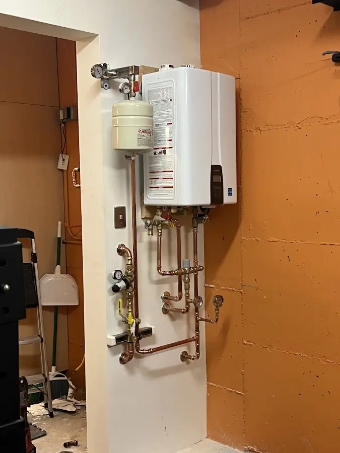 Plumbing technician inspecting water heater connections in Millcreek